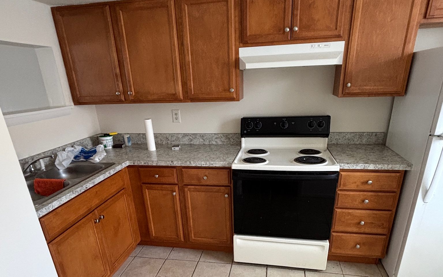 An original kitchen before renovation, with oak cabinets and tile floors