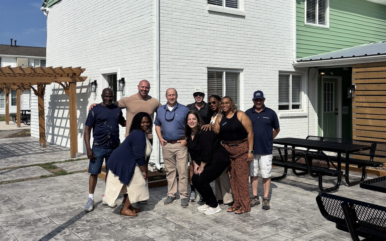 The Avalon team outside a renovated building with a new patio and pergola