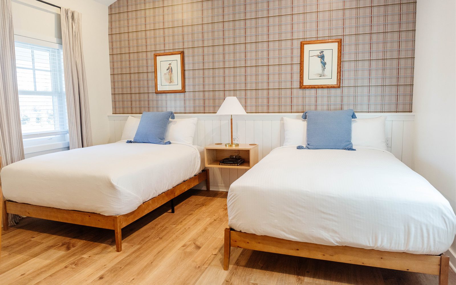 A Rochambeau guest room with two beds and a plaid accent wall